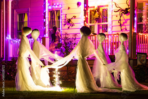 Illuminated Halloween house ghosts decoration at night photo