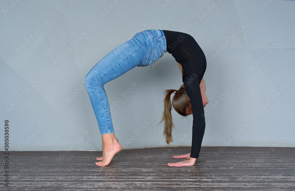 Young attractive woman practicing yoga near floor wall, standing in Bridge exercise, working out. selective focus