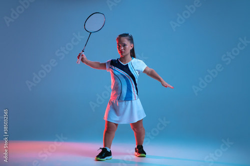 Action. Beautiful dwarf woman practicing in badminton isolated on blue background in neon light. Lifestyle of inclusive people, diversity and equility. Sport, activity and movement. Copyspace for ad. © master1305