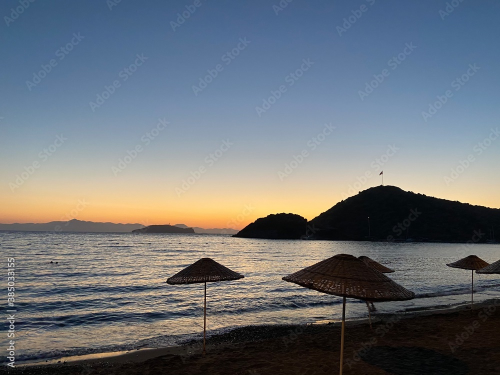 Beautiful sea view at sunset, colorful at dawn, reflections on the sea, sun shades, lights and islands on the aegean sea. 