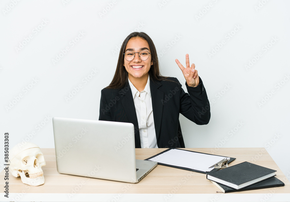 Young traumatologist asian woman isolated on white background showing victory sign and smiling broadly. Young traumatologist asian woman isolated on white background showing victory sign and smiling broadly.