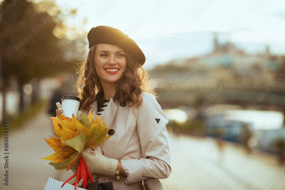 Φωτογραφία woman with shopping bags, cup of coffee and autumn leaves