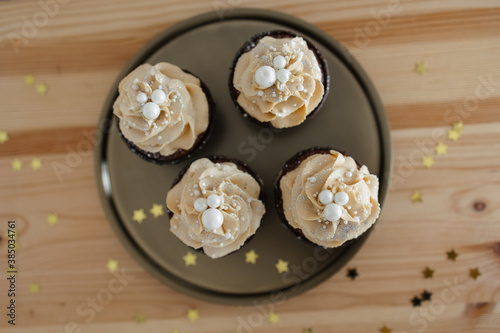 chocolate cupcakes with caramel cream decorated with silver on a gold tray