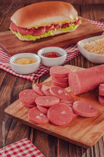 Slices of big sausage with ketchup and mustarde sauce photo