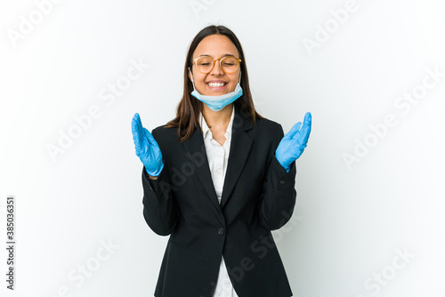 Young business latin woman wearing a mask to protect from covid isolated on white background joyful laughing a lot. Happiness concept.