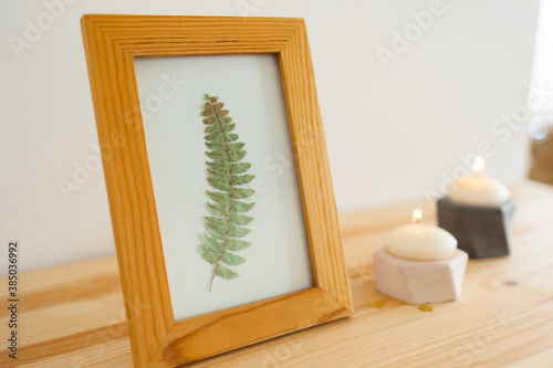 wooden frame with a leaf on the shelf