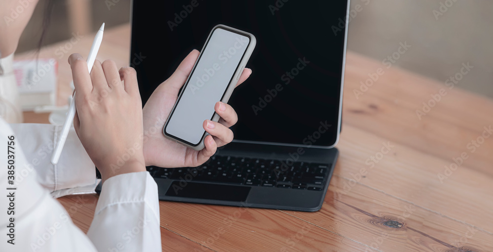 Φωτογραφία Cropped shot of female hands holding stylus pen and blank screen smartphone while sitting at the table in office room
