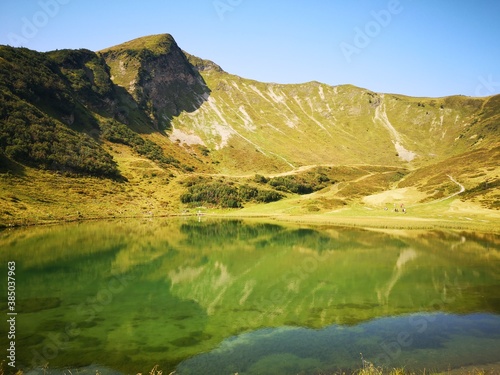 mountain reflection on lake Alp mountains near Oberstdorf Bayern Germany green trekking path in a sunny day of September