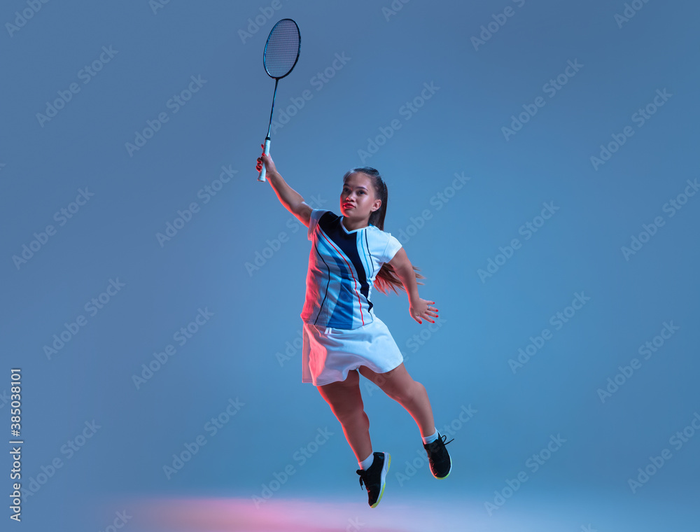 Winner. Beautiful dwarf woman practicing in badminton isolated on blue background in neon light. Lifestyle of inclusive people, diversity and equility. Sport, activity and movement. Copyspace.