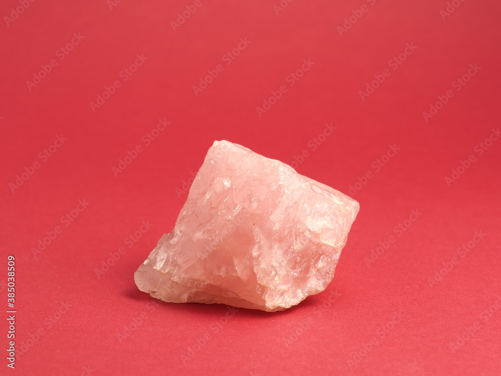 Rose quartz on a red background, mineral, healing stone Rose quartz on a red background, mineral, healing stone
