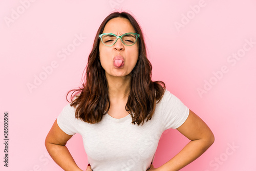 Young mixed race hispanic woman isolated funny and friendly sticking out tongue.