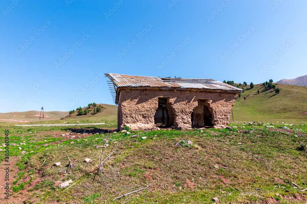 An old abandoned house. No people. The building is made of adobe and wood. House in the mountains of Kyrgyzstan.