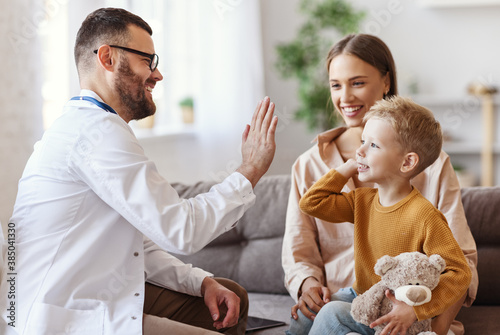 Tela family doctor pediatrician conducts examination of   child boy and giving high five to him