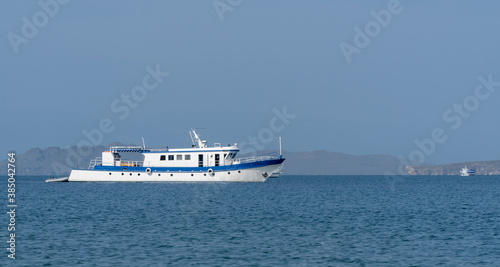 small white boat on the blue water surface. transport for water walks and fishing