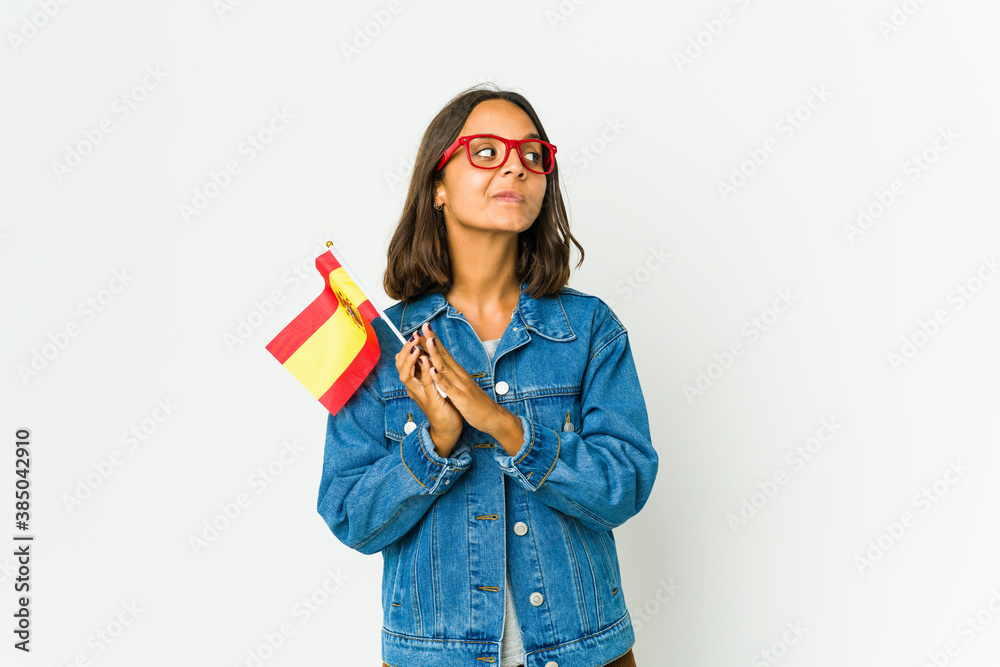Young spanish woman holding a flag isolated on white background Young spanish woman holding a flag isolated on white background