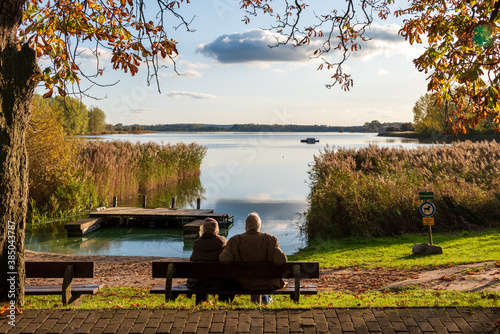 Herbstliche Stimmung am Passader See in Schleswig-Holstein, ein altes Ehepaar genießt die Herbstsonne