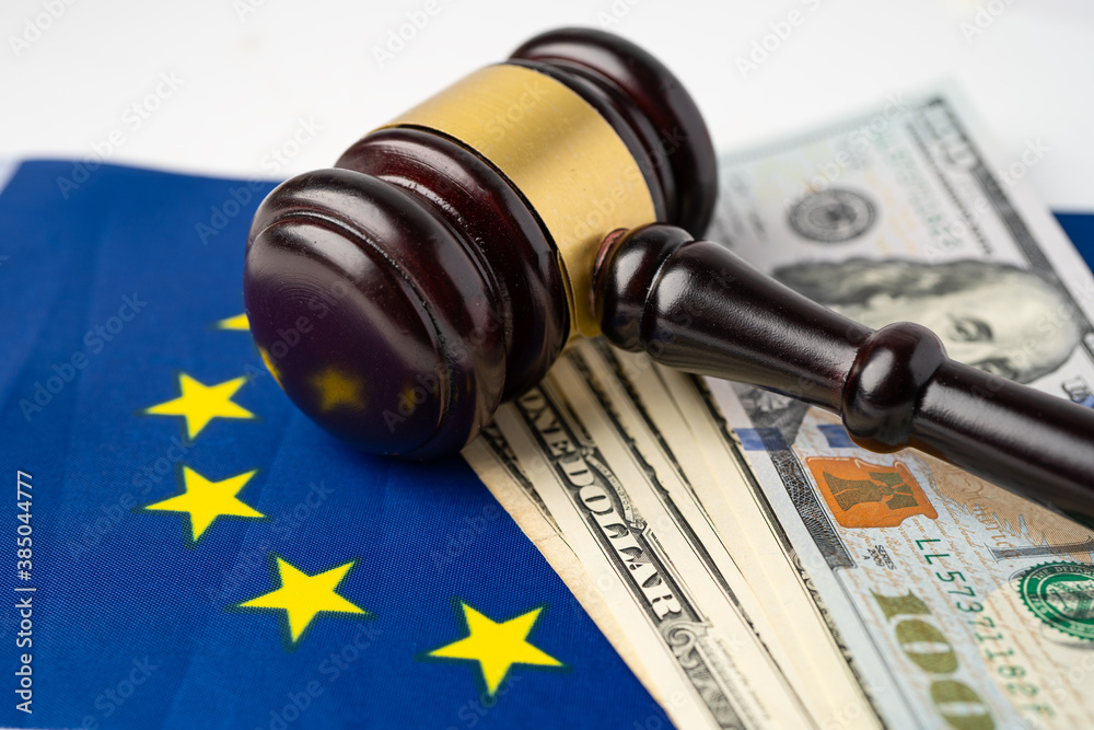 Gavel for judge lawyer and US dollar banknotes on Eu flag, finance concept.