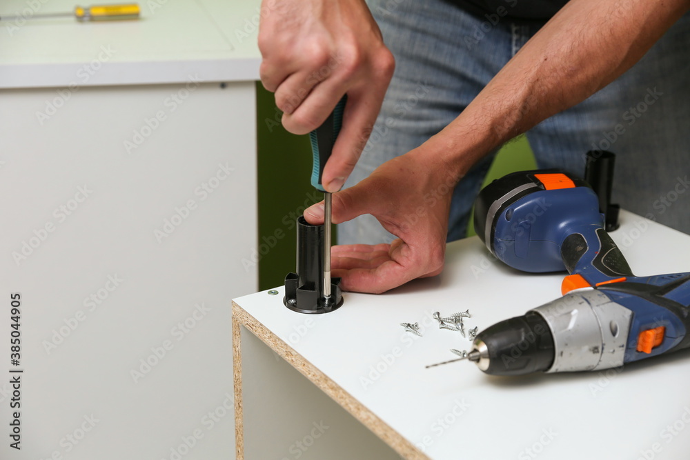 furniture assembly service concept. worker assembles furniture in the kitchen