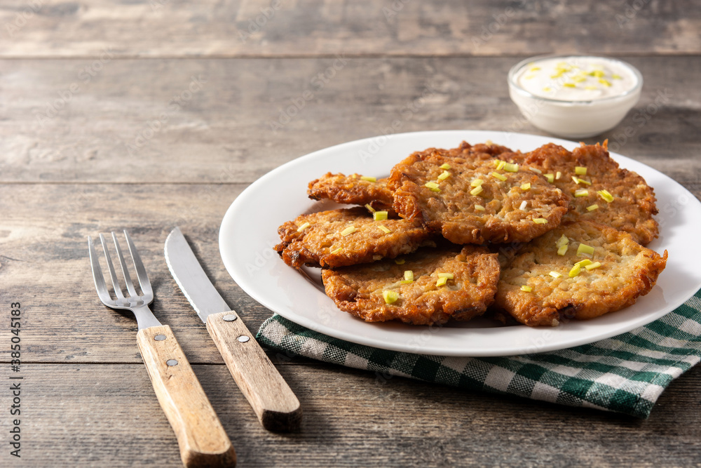 Traditional Jewish latkes or potato pancakes on wooden table.Copy space