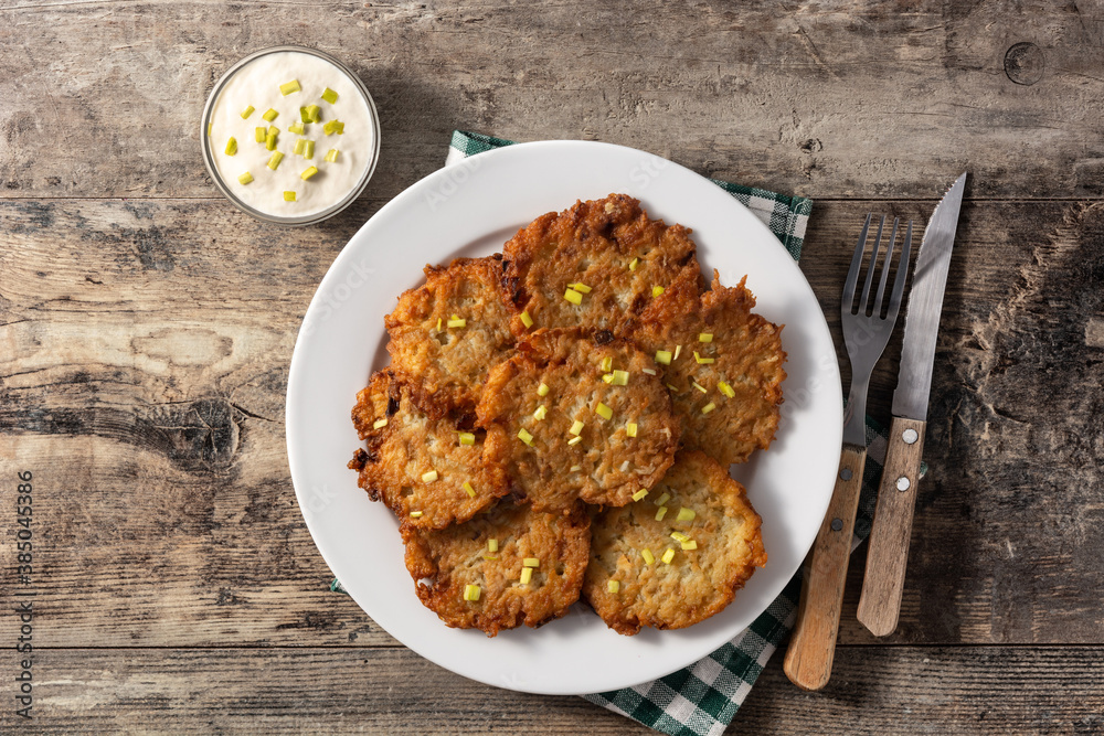 Traditional Jewish latkes or potato pancakes on wooden table.Top view Traditional Jewish latkes or potato pancakes on wooden table.Top view
