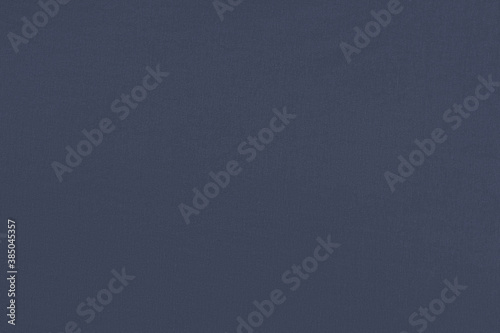 Dark blue homogeneous background with a textured surface, fabric.