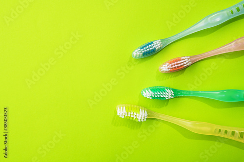 New colored toothbrushs on a green background