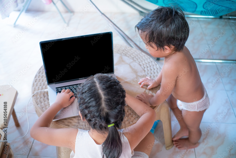 Cute and happy little girl children using laptop computer studying online internet Cute and happy little girl children using laptop computer studying online internet