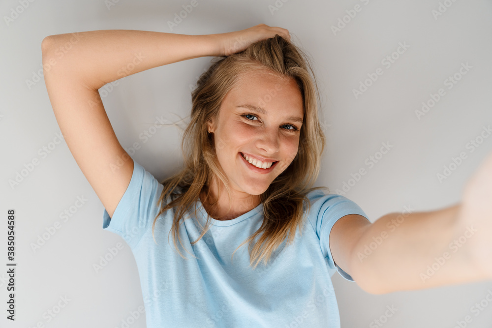 Beautiful joyful caucasian girl smiling while taking selfie photo Beautiful joyful caucasian girl smiling while taking selfie photo