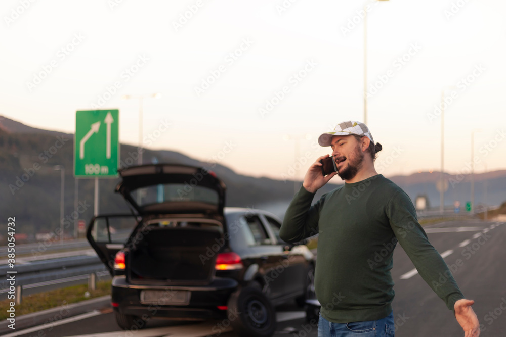Frustrated and angry man calls roadside assistance by phone. Car problem.