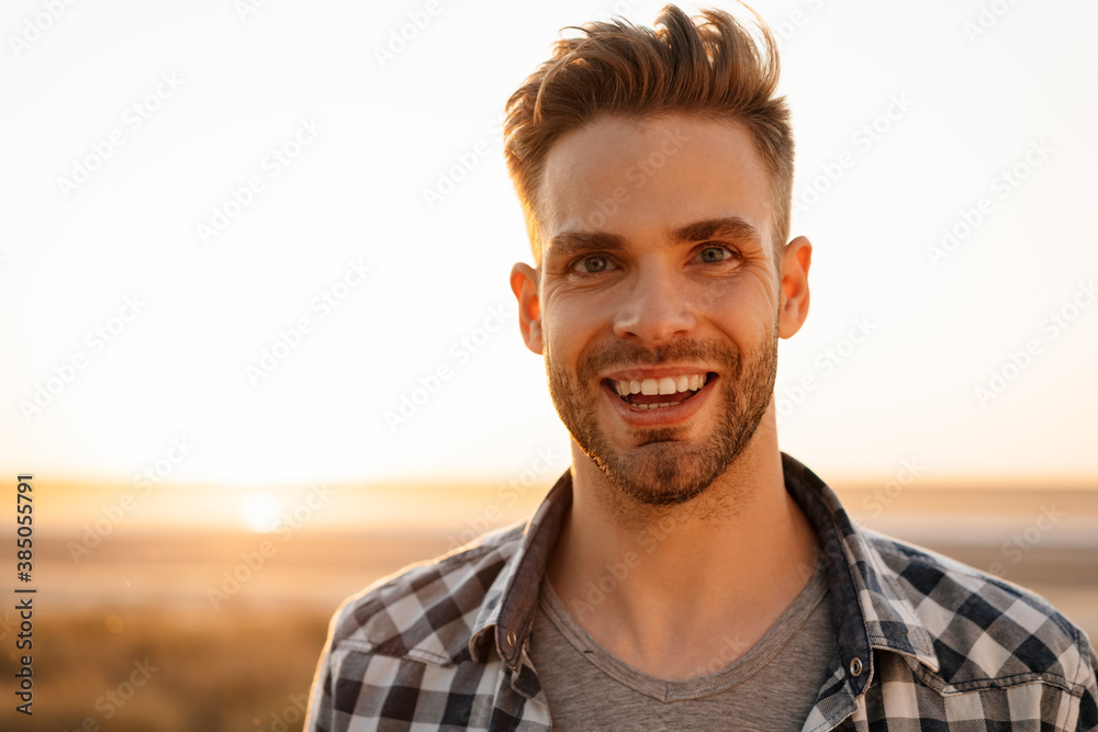 Handsome happy guy smiling and looking at camera on nature at summer Handsome happy guy smiling and looking at camera on nature at summer