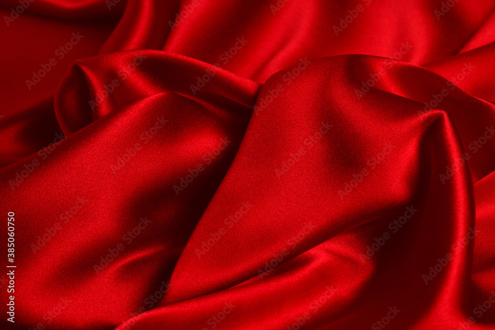 Red silk or satin luxury fabric texture can use as abstract background. Top view.
