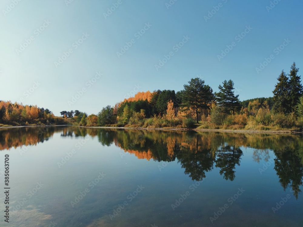 autumn landscape with reflection of trees on the lake surface