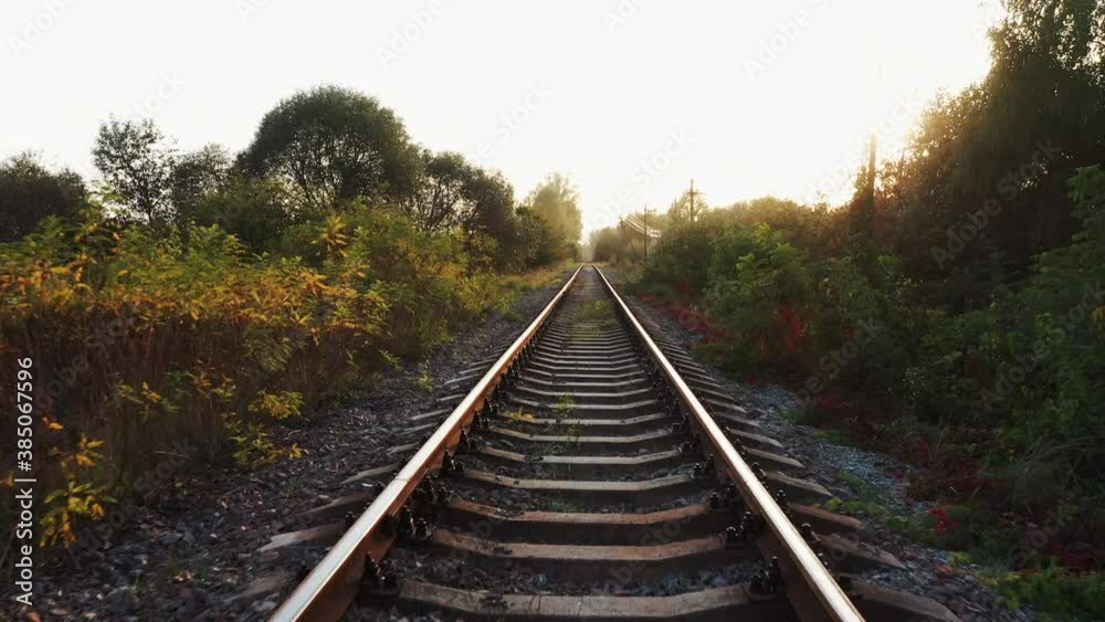 Railroad track at sunset in the countryside. Low flight of a drone over the railway. Railroad track at sunset in the countryside. Low flight of a drone over the railway.
