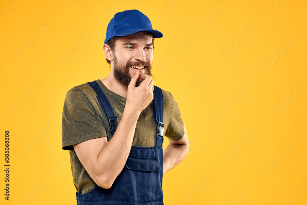 Worker man in uniform worker service yellow background emotion