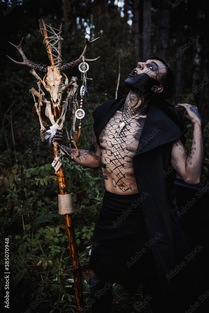 Sorcerer with marks on his body in the forest