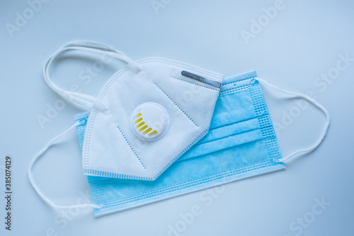 Respirator with exhalation valve and medical protective mask on a blue background