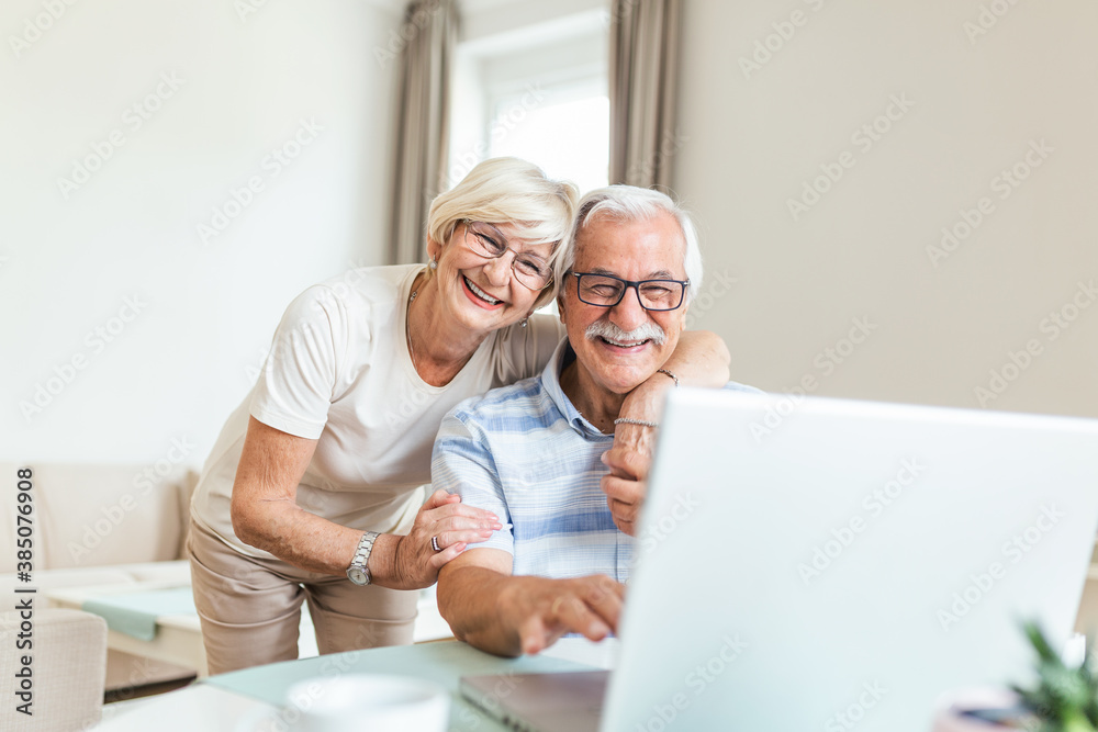 Elderly spouses at home. Wife hugs husband. Having pleasant conversation chatting with grown up children and grand children using wireless tech concept Elderly spouses at home. Wife hugs husband. Having pleasant conversation chatting with grown up children and grand children using wireless tech concept