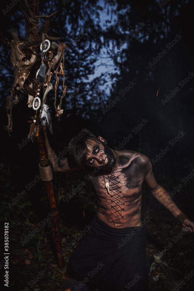 Naklejka premium Sorcerer with marks on his body in the forest
