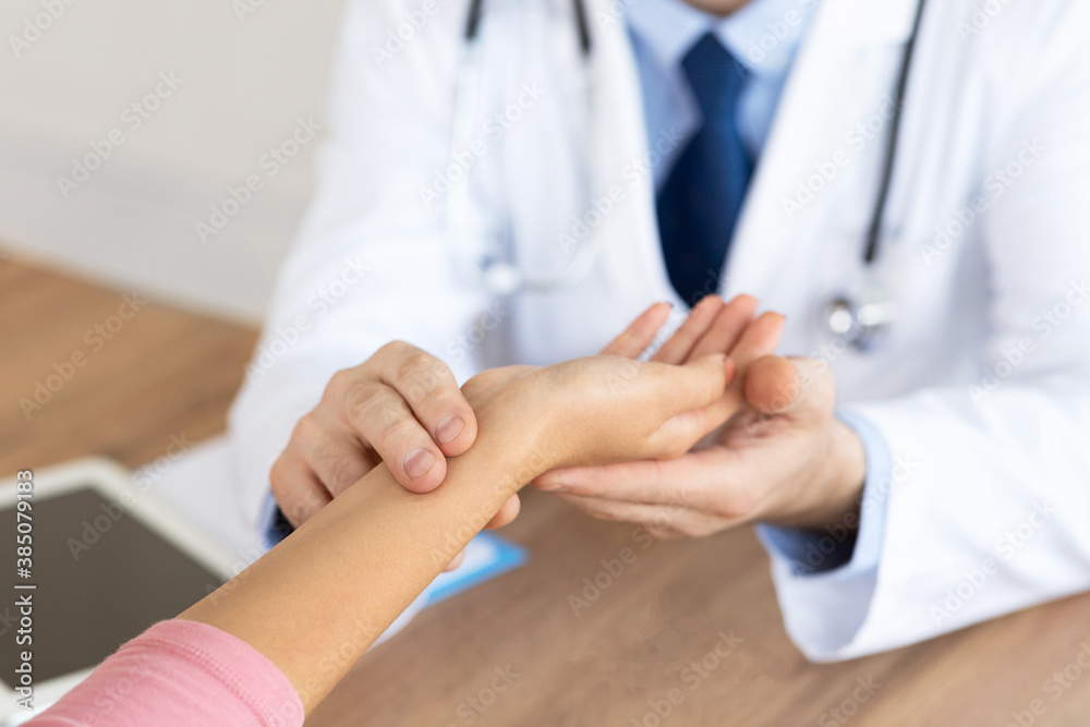 Doctor checking measuring pressure on patient's hand pulse Doctor checking measuring pressure on patient's hand pulse