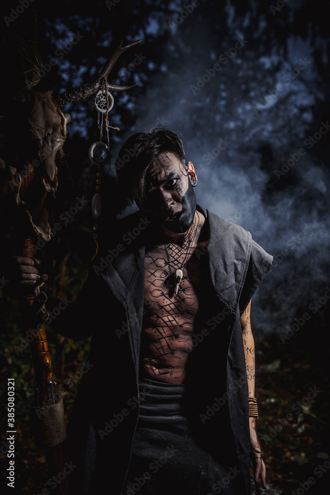 Sorcerer with marks on his body in the forest Sorcerer with marks on his body in the forest