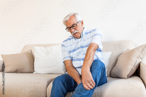 Pain in the leg of an elderly man. Senior man holding painful muscle, sprain or cramp ache © Graphicroyalty