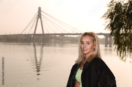 Young blonde woman on a bridge background