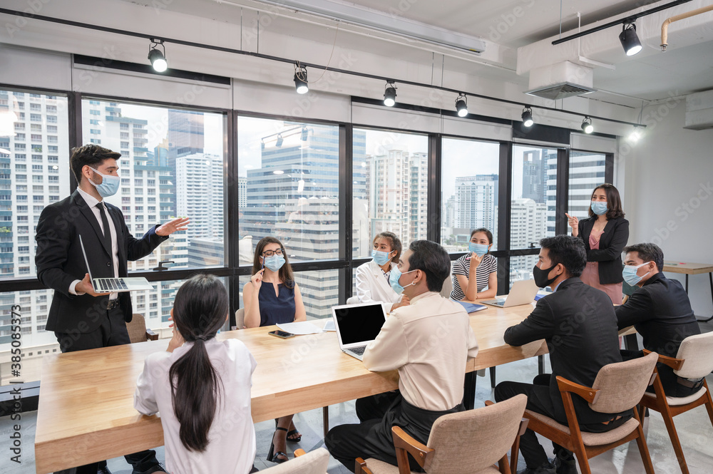 Caucasian businessman presentation of business plan on laptop at conference table, Group of business people wearing face mask meeting in modern office Caucasian businessman presentation of business plan on laptop at conference table, Group of business people wearing face mask meeting in modern office