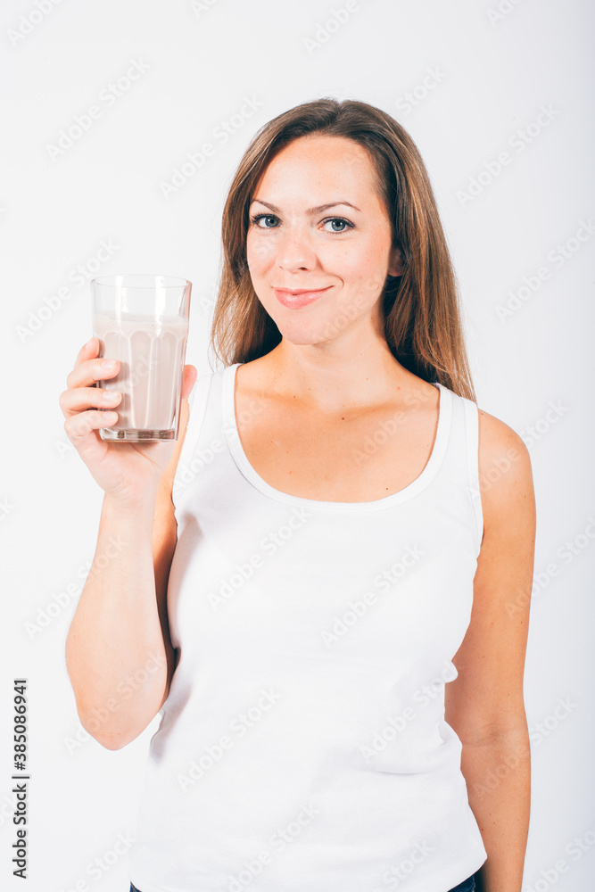 blond woman holding a glass with chocolate milk and smiling at camera blond woman holding a glass with chocolate milk and smiling at camera