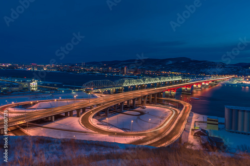 A new road bridge over the Yenisei. connecting two parts of the city, next to the railway, illuminated by bright lights