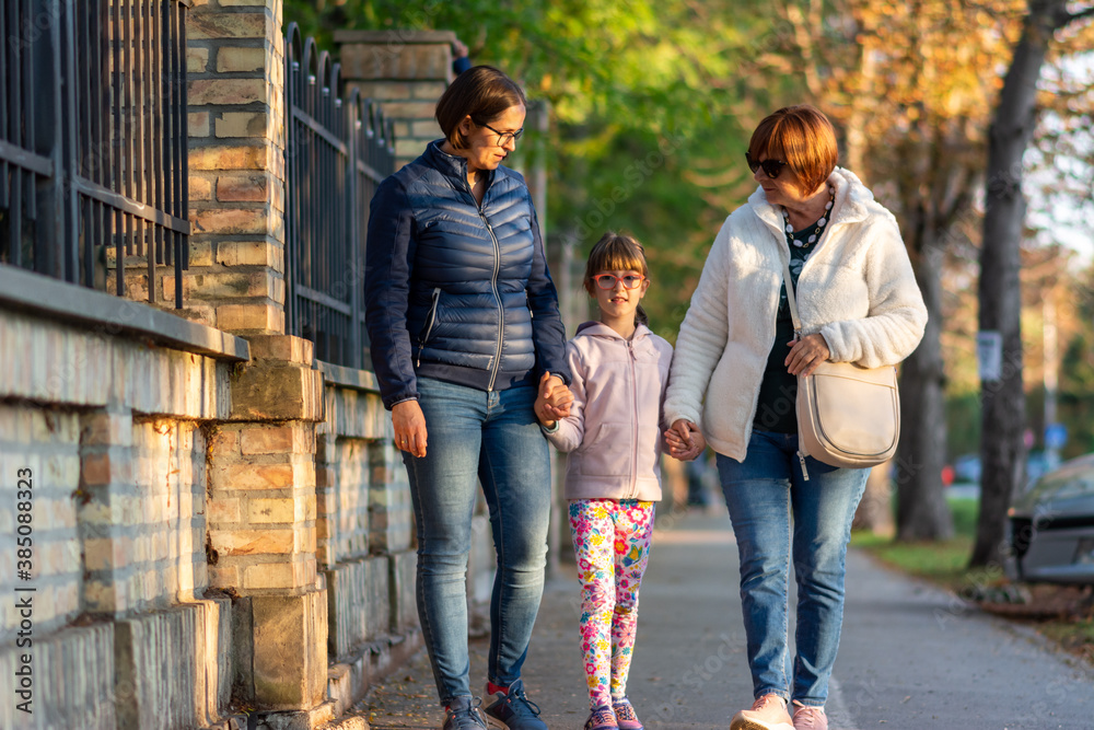 Obraz premium Happy smiling mother, daughter and grandmother walking at park. 