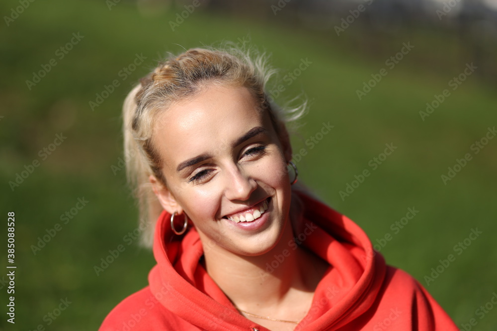 Beautiful young blonde woman smiling outside