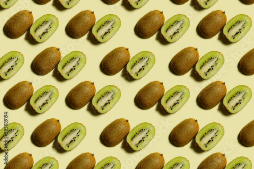 Wallpaper Mural Kiwi pattern. Repetition of kiwi halves on a light yellow background. Top view of green and brown kiwi halves on a light surface. Horizontal. The concept of healthy food and vegetarianism. Torontodigital.ca
