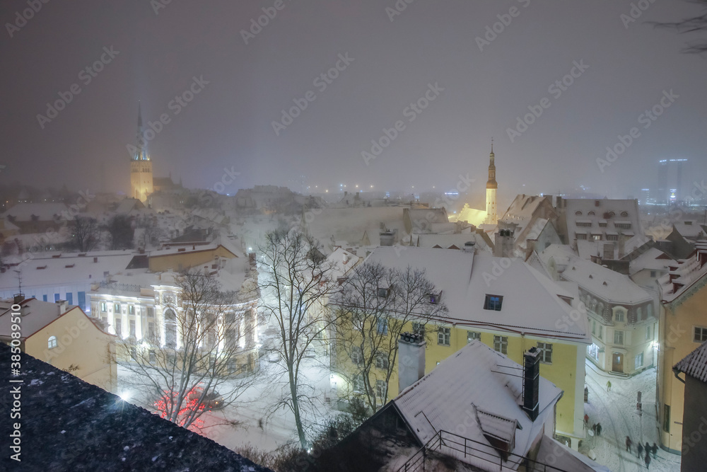 Winter night view from Kohtuotsa viewing platform to historic medieval downtown and modern city of Tallinn, obscured by the heavy snowstorm and creating winter wonderland dreamy look