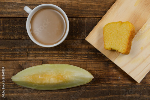 Brazilian breakfast with coffee with milk, corn cake and watermelon